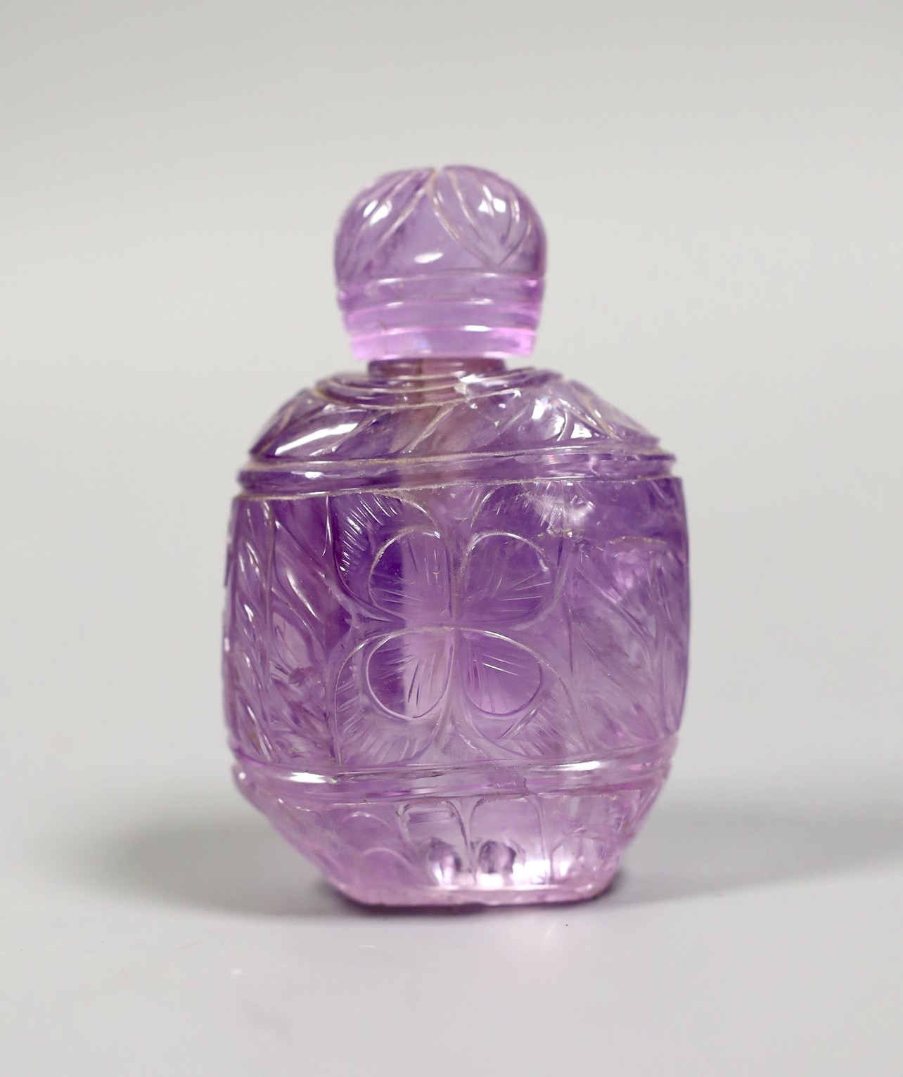 A carved amethyst quartz scent bottle and stopper, 9.5 cms high